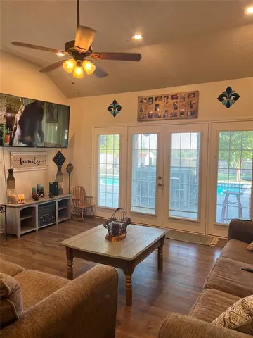 a living room with furniture a chandelier and a flat screen tv