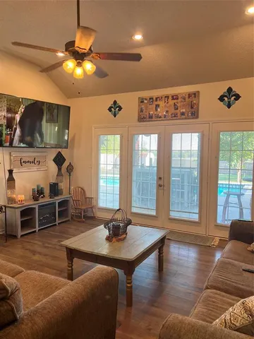 a living room with furniture a chandelier and a flat screen tv