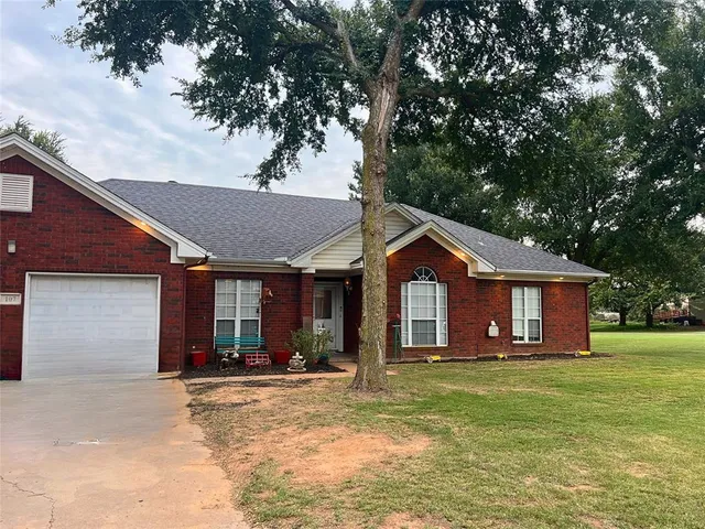 a front view of a house with a yard and trees