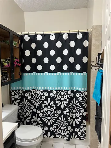 a bathroom with a toilet and a shower curtain
