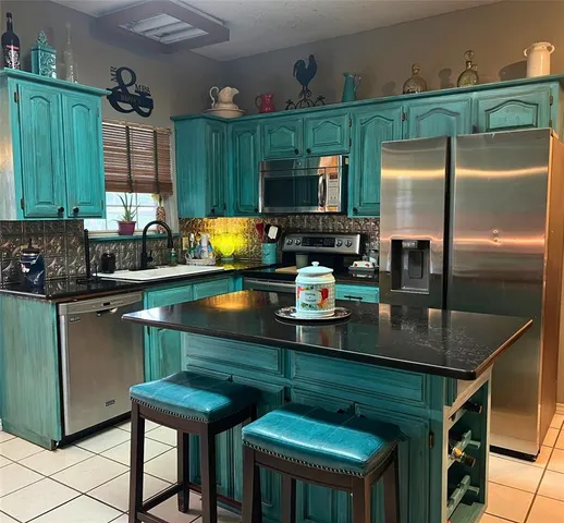 a kitchen with stainless steel appliances granite countertop a sink a stove and a refrigerator