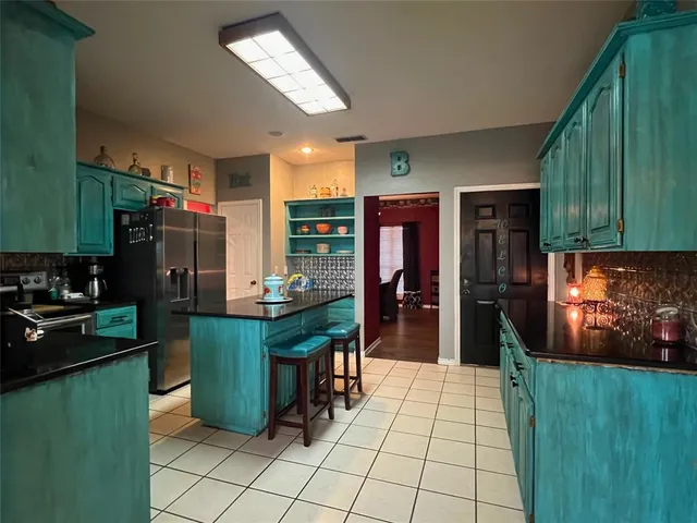 a kitchen with stainless steel appliances granite countertop a refrigerator and a stove top oven