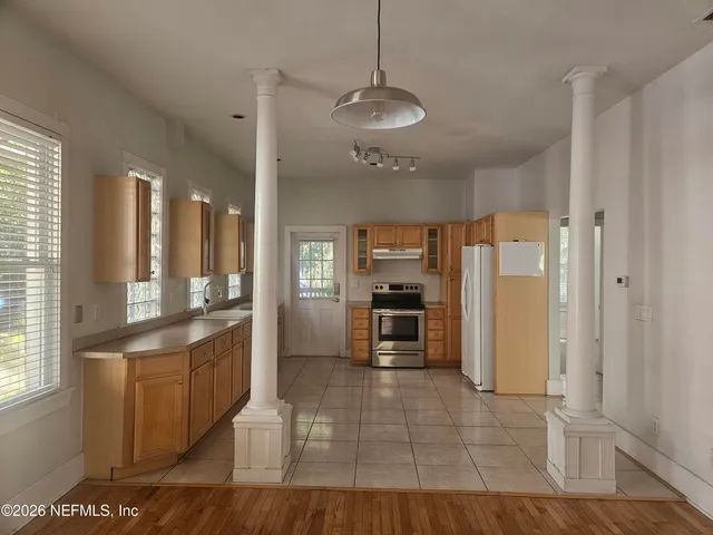 a open kitchen with stainless steel appliances granite countertop a refrigerator and a stove top oven