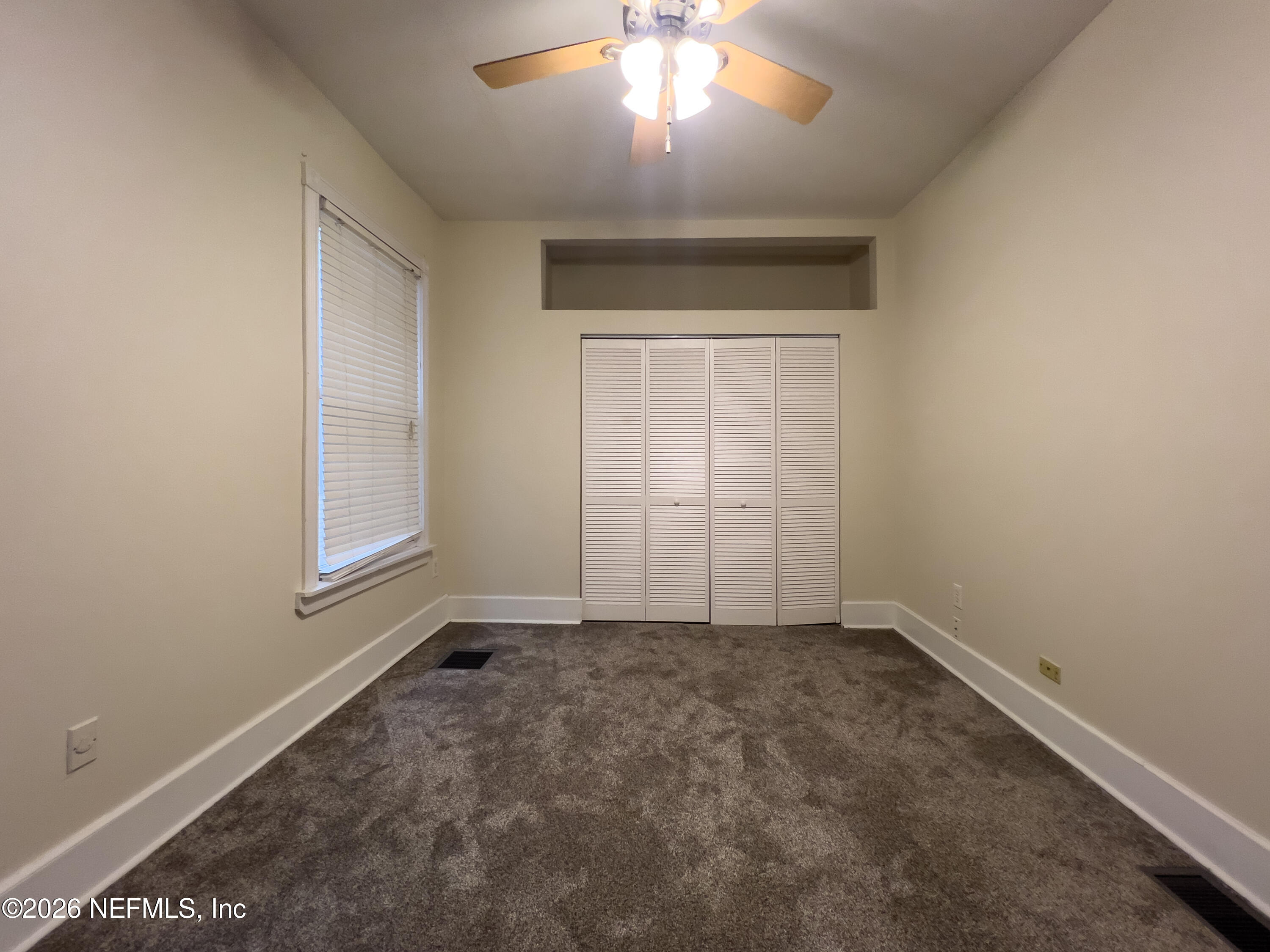 1425 Silver Street Jacksonville, FL 32206 - Photo 10 of 20 an empty room with a chandelier fan and windows