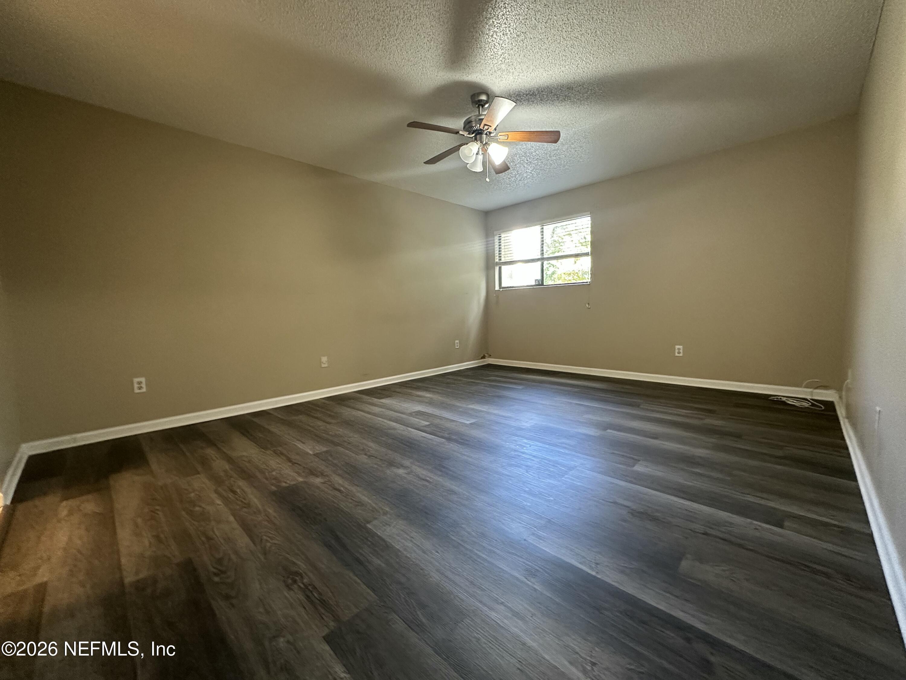 3801 Crown Point Road, Unit 3081 Jacksonville, FL 32257 - Photo 25 of 34 a view of an empty room with wooden floor and a window