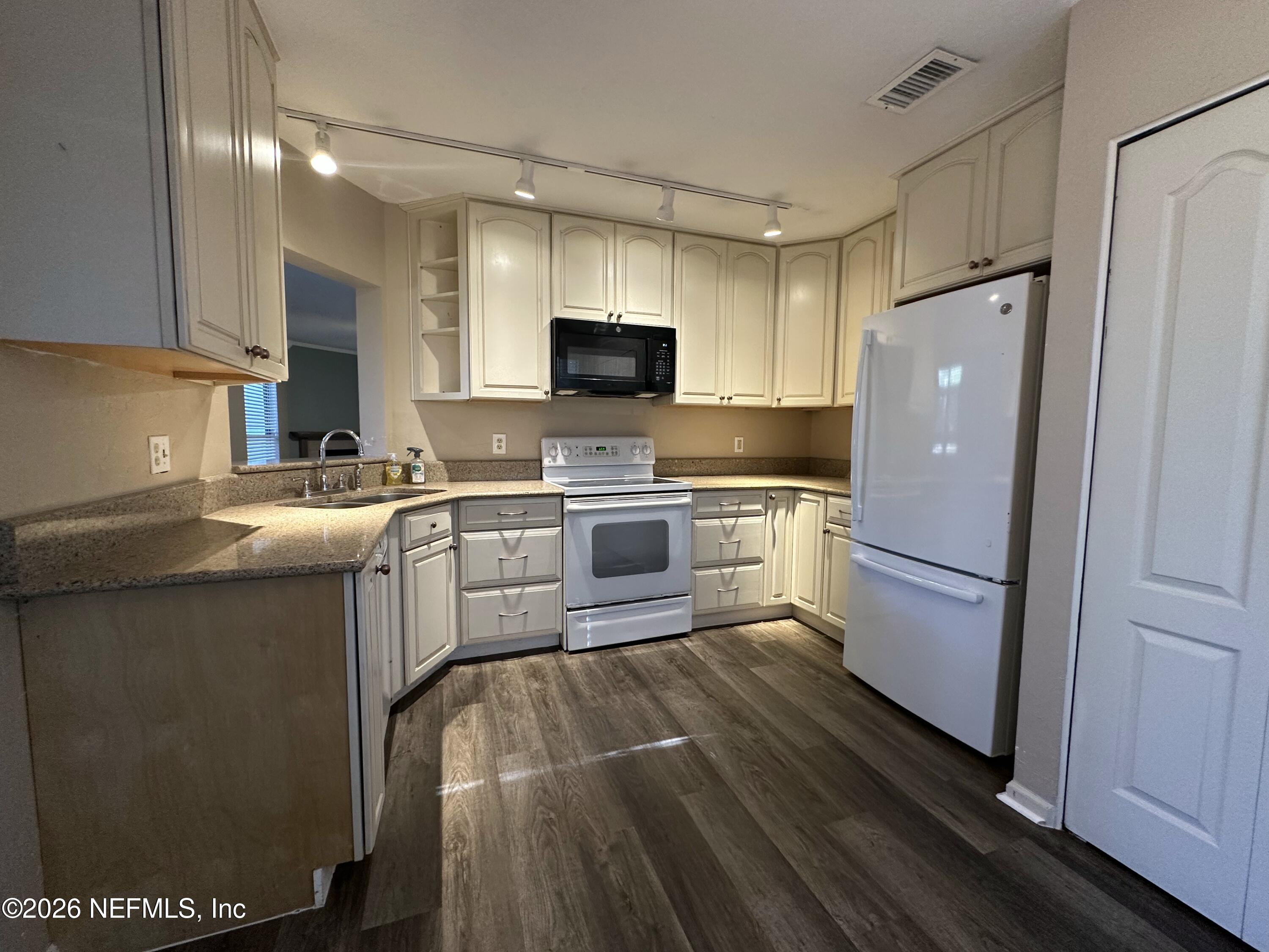 3801 Crown Point Road, Unit 3081 Jacksonville, FL 32257 - Photo 4 of 34 a kitchen with a sink a refrigerator and a stove top oven with wooden floor