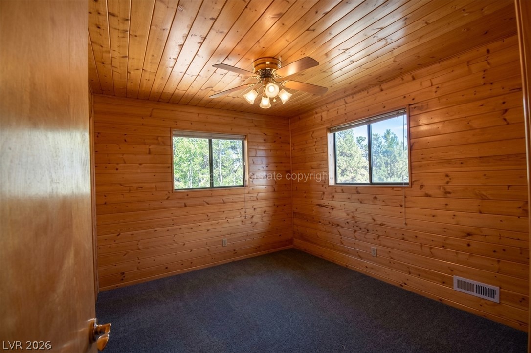 1129 East Ponderosa Road Hatch, UT 84735 - Photo 25 of 47 Rich wood planking lines the walls and ceiling of this rustic cabin bedroom.