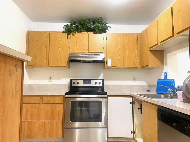 a kitchen with a sink a stove and cabinets