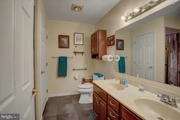 a bathroom with a sink double vanity granite and a toilet