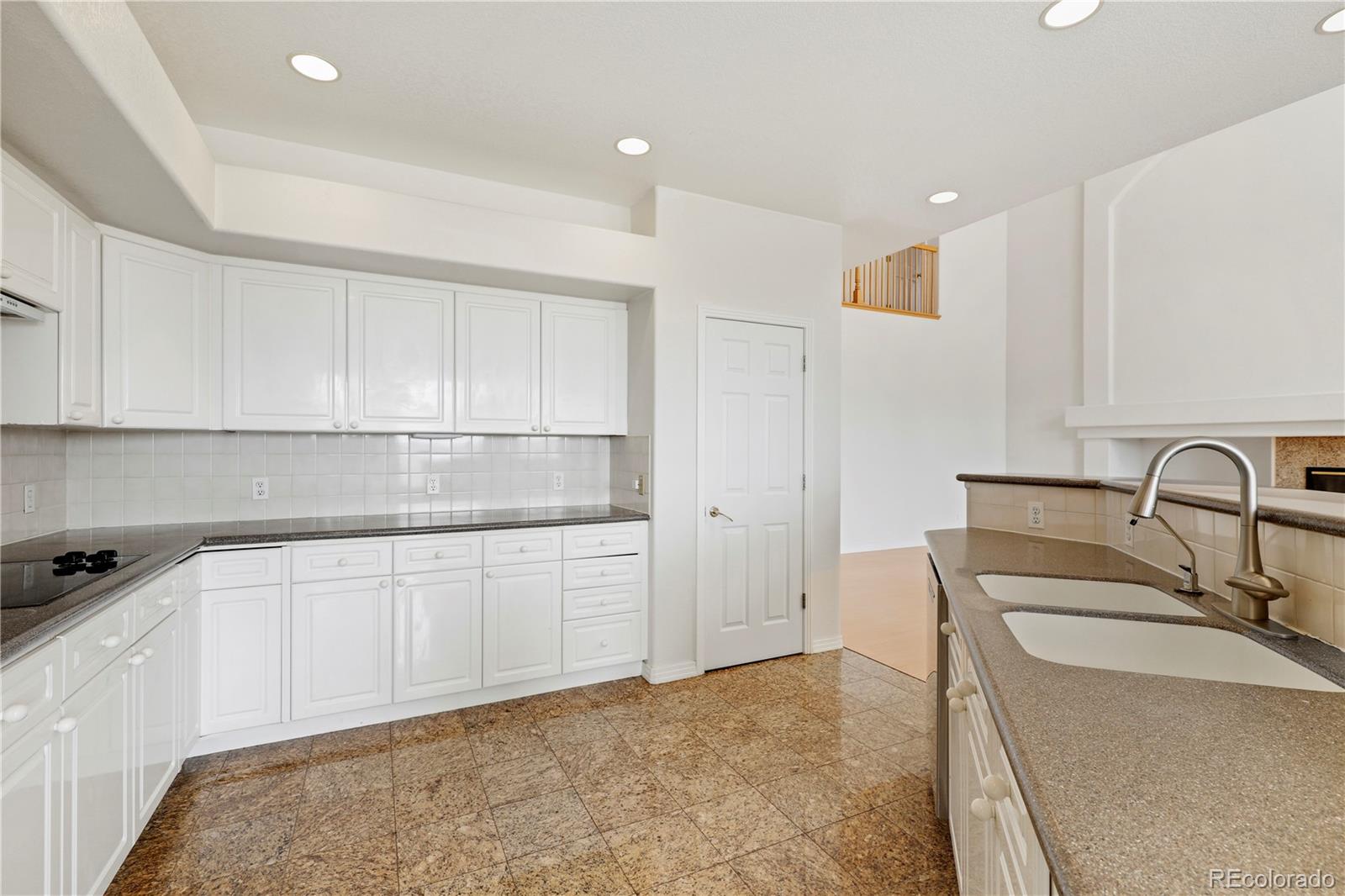 5662 South Nome Street Englewood, CO 80111 - Photo 17 of 47 a kitchen with granite countertop white cabinets and stainless steel appliances