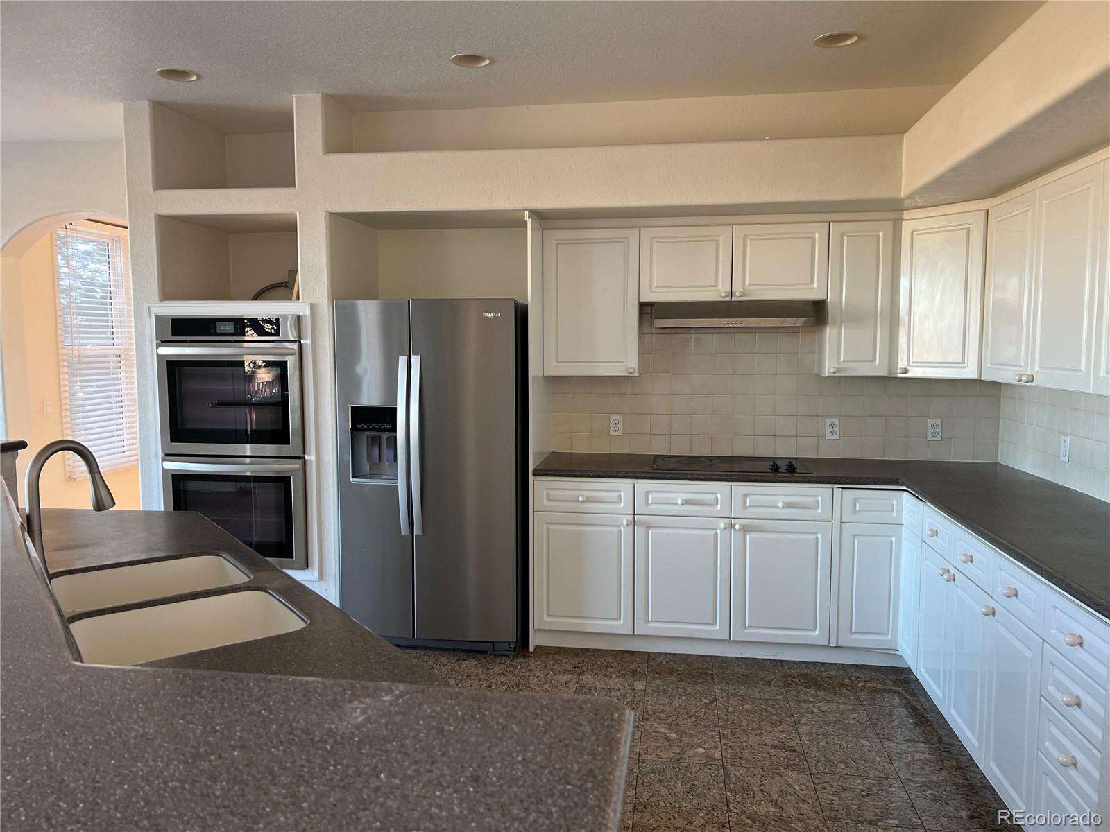 5662 South Nome Street Englewood, CO 80111 - Photo 19 of 47 a kitchen with stainless steel appliances granite countertop a refrigerator and a sink