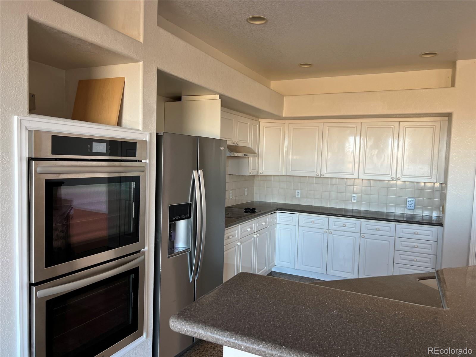5662 South Nome Street Englewood, CO 80111 - Photo 20 of 47 a kitchen with stainless steel appliances granite countertop a stove a refrigerator and a microwave