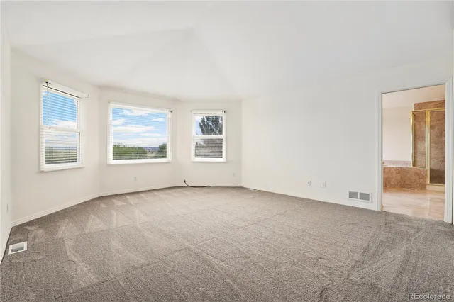 a spacious bathroom with a tub sink and mirror