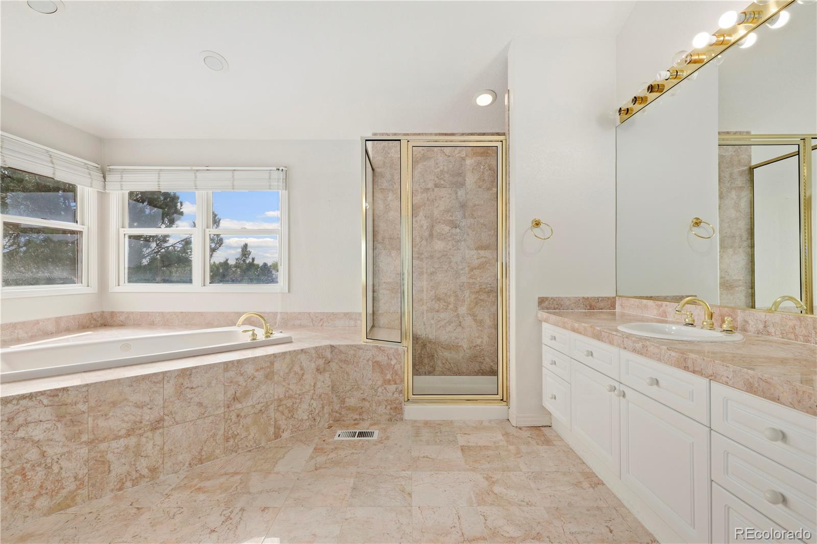 5662 South Nome Street Englewood, CO 80111 - Photo 34 of 47 a spacious bathroom with a tub sink and mirror