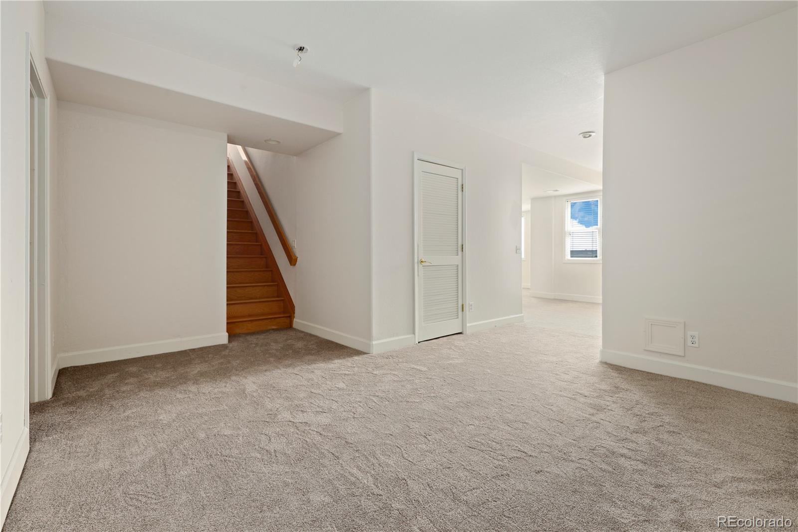 5662 South Nome Street Englewood, CO 80111 - Photo 37 of 47 an empty room with staircase and white door