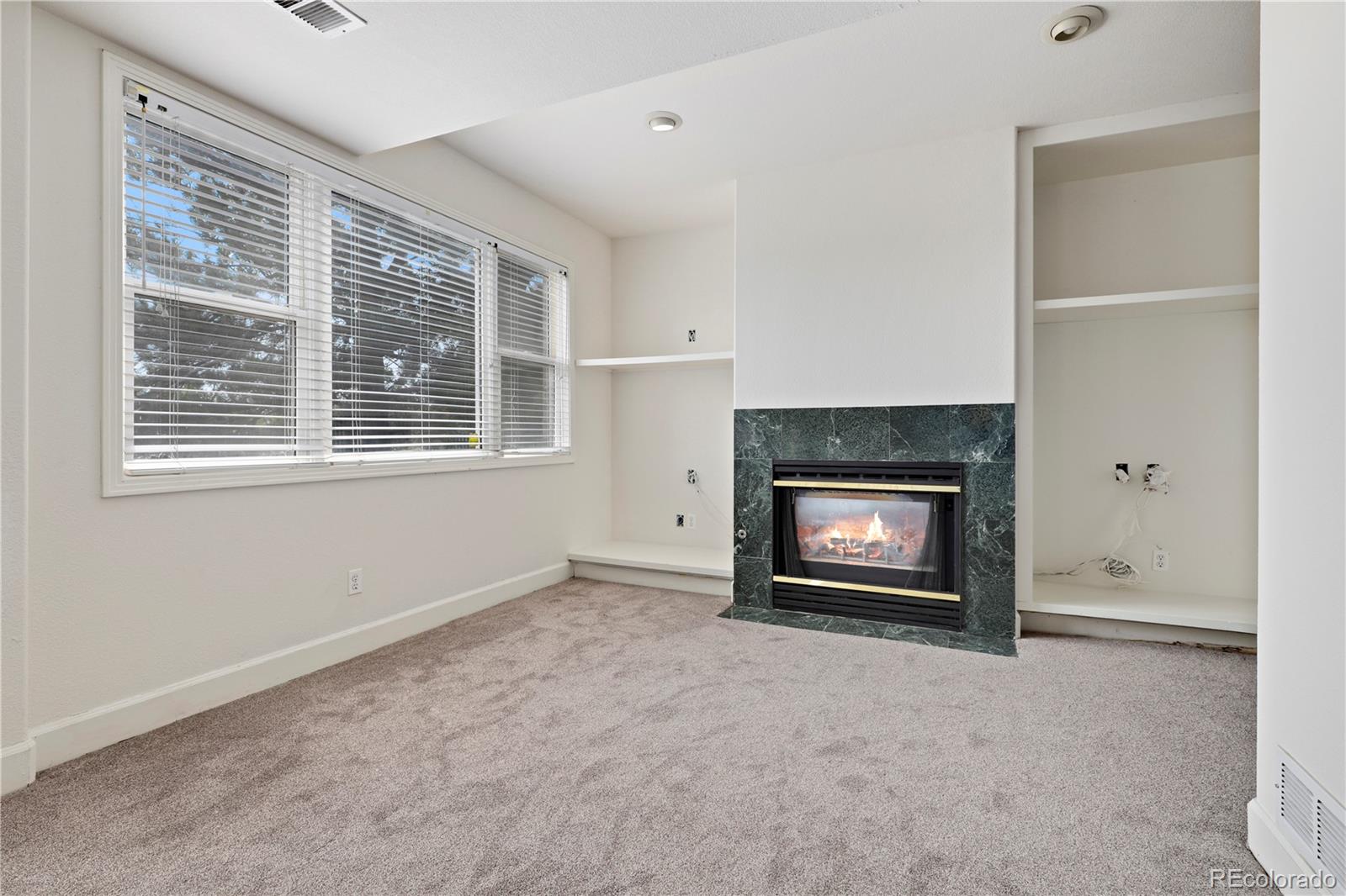 5662 South Nome Street Englewood, CO 80111 - Photo 39 of 47 a view of an empty room with a fireplace and a window