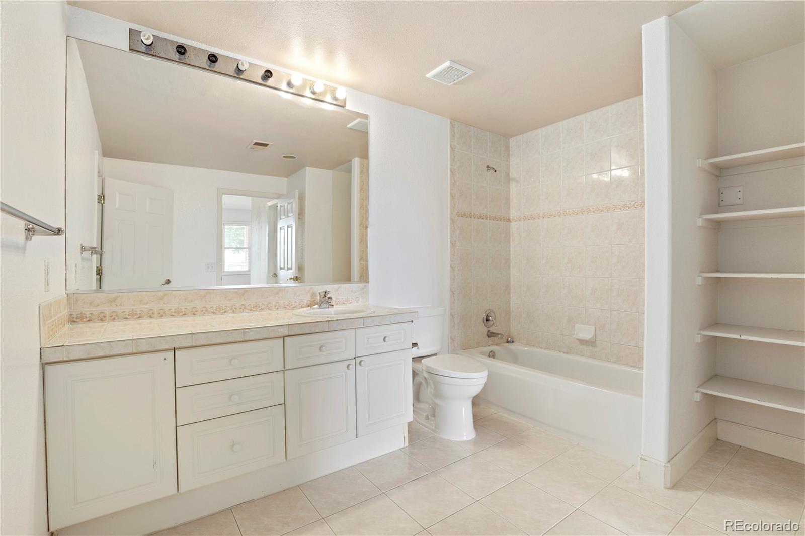 5662 South Nome Street Englewood, CO 80111 - Photo 44 of 47 a spacious bathroom with a double vanity sink a toilet and a bathtub