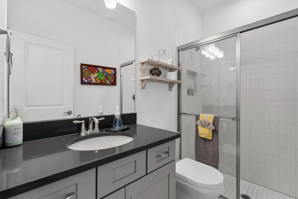 9291 Starry Night Avenue Sarasota, FL 34241 - Photo 13 of 30 a bathroom with a granite countertop sink toilet a mirror and shower