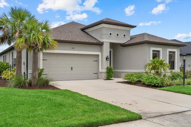 a front view of a house with a garden and palm tree
