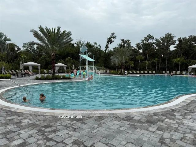 a view of a backyard with swimming pool and furniture
