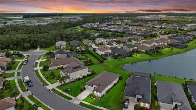 an aerial view of a city with lots of residential buildings and mountain view in back