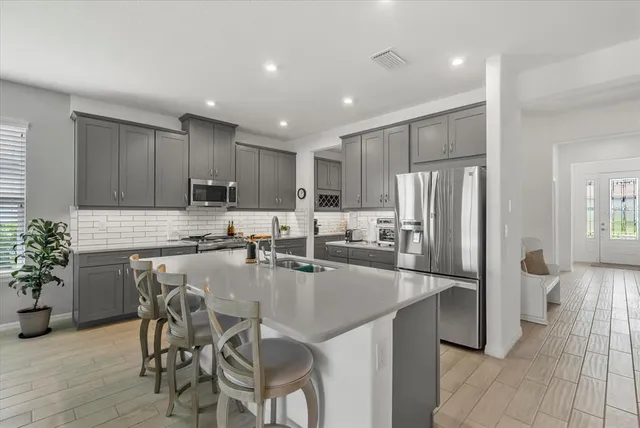 a kitchen with granite countertop a refrigerator and a stove top oven