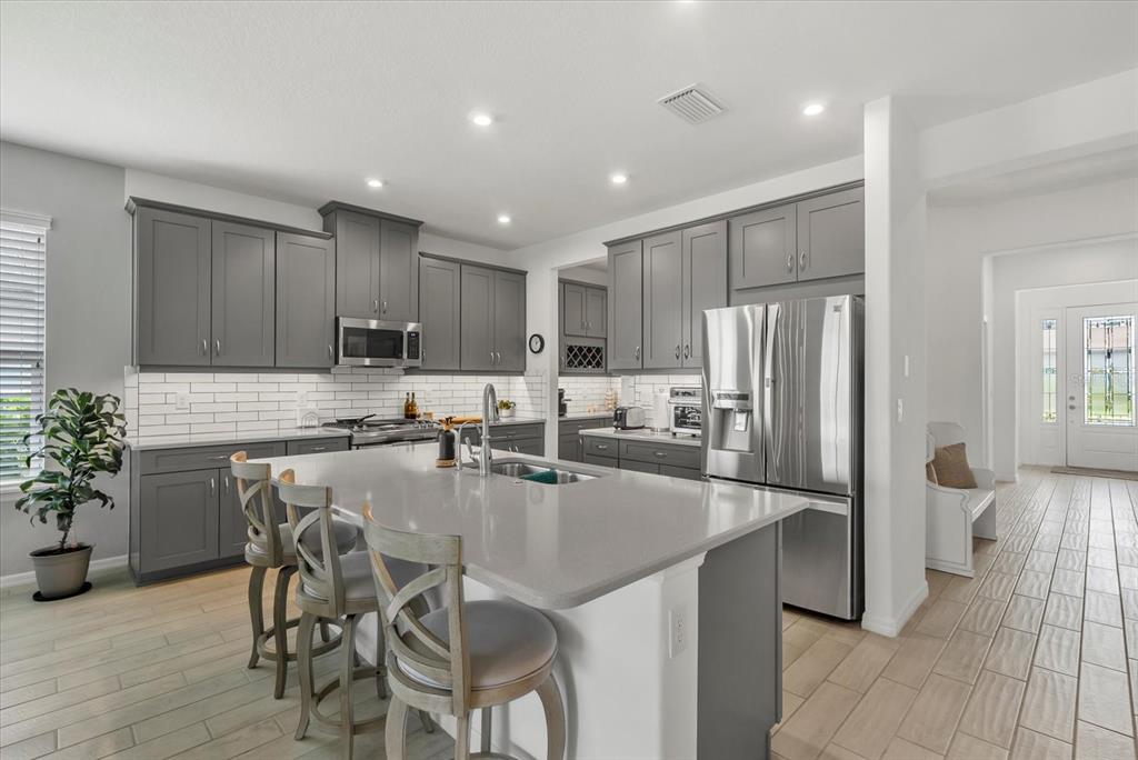 9291 Starry Night Avenue Sarasota, FL 34241 - Photo 6 of 30 a kitchen with granite countertop a refrigerator and a stove top oven