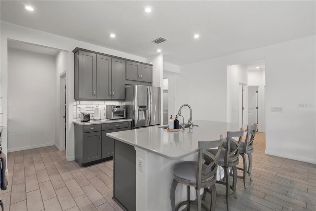 9291 Starry Night Avenue Sarasota, FL 34241 - Photo 7 of 30 a large kitchen with sink a refrigerator and chairs
