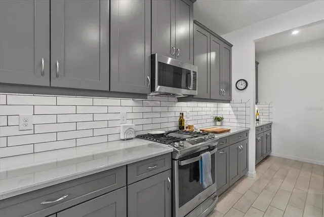 a kitchen with stainless steel appliances granite countertop a sink stove and cabinets