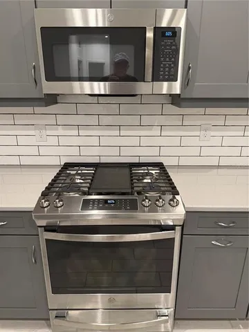 a stove top oven sitting inside of a kitchen