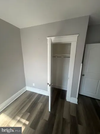 an empty room with wooden floor and closet