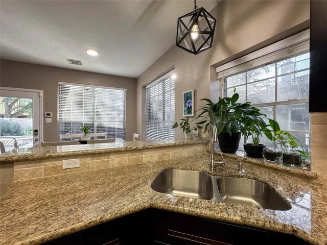 a kitchen with granite countertop a sink and a large window