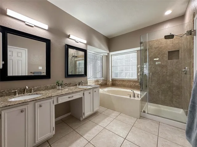 a spacious bathroom with a bathtub sink mirror and toilet