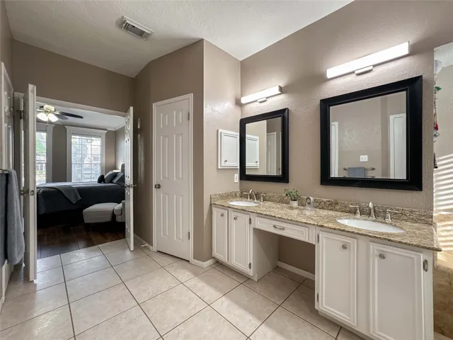 a en suite bathroom with a granite countertop sink a mirror and a