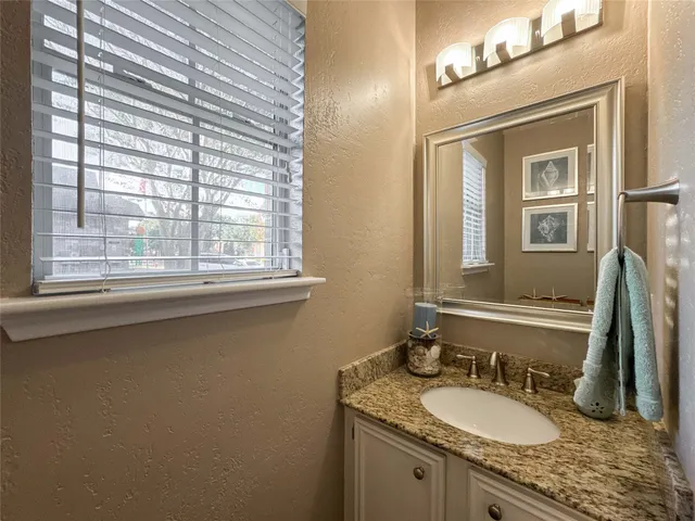 a bathroom with a granite countertop sink a mirror and a window