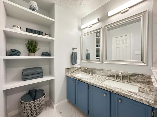 a bathroom with a granite countertop sink and a washing machine