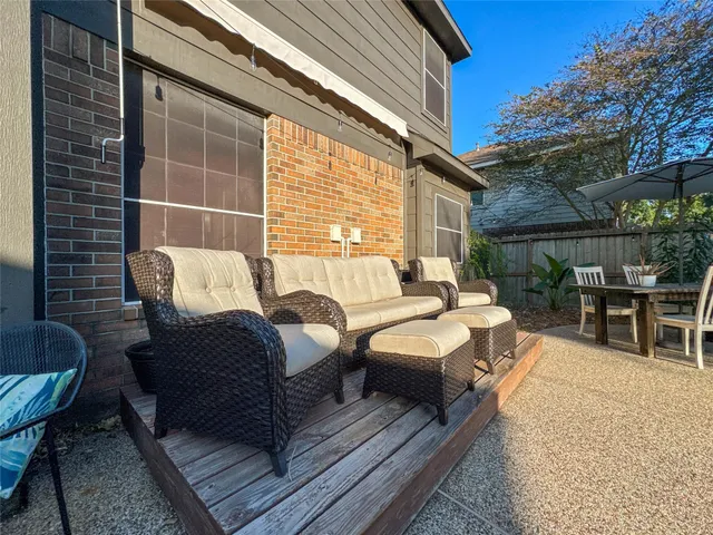 a view of a patio with couches and a table and chairs with wooden floor