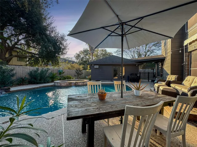 a roof deck with table and chairs under an umbrella