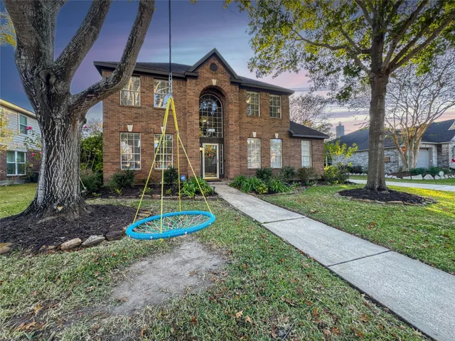a front view of a house with a yard fire pit and large trees