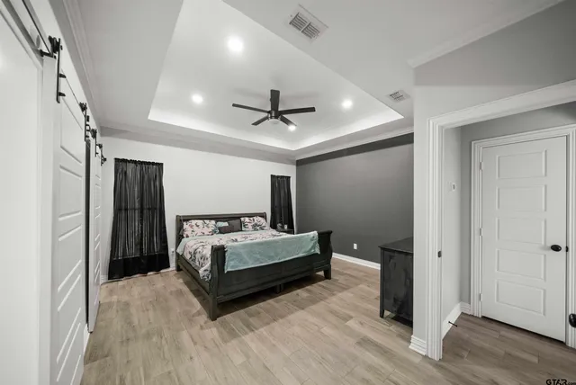 a spacious bedroom with a bed and a ceiling fan