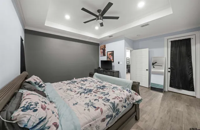 a bedroom with a large bed and a chandelier