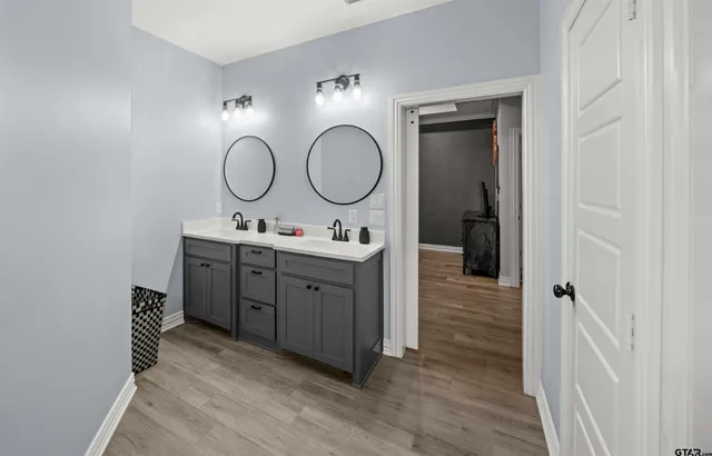 a bathroom with a double vanity sink mirror and a toilet