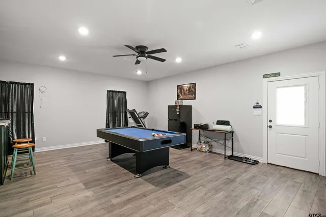 a living room with furniture a flat screen tv and a wooden floor