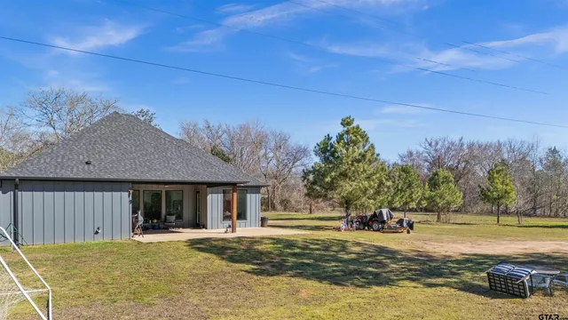 a view of a house with pool and a yard