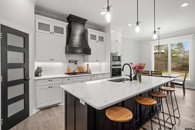 a kitchen with granite countertop a table chairs sink and stove