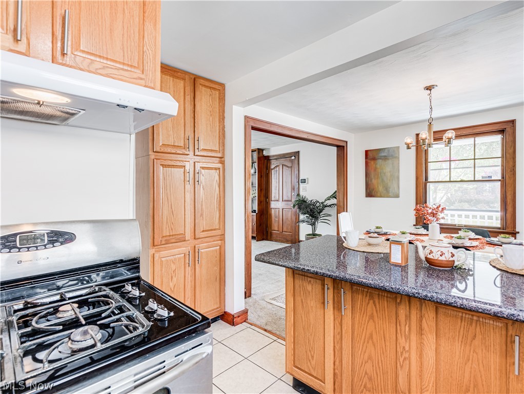 377 East Wilbeth Road Akron, OH 44301 - Photo 11 of 25 Kitchen featuring light tile floors, a notable chandelier, stainless steel range oven, dark stone countertops, and pendant lighting