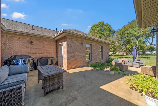 a backyard of a house with barbeque oven and a table and chairs