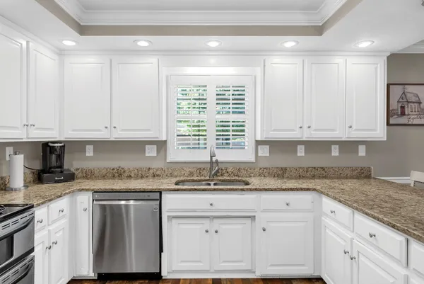a large kitchen with a refrigerator a sink dishwasher a dining table and chairs