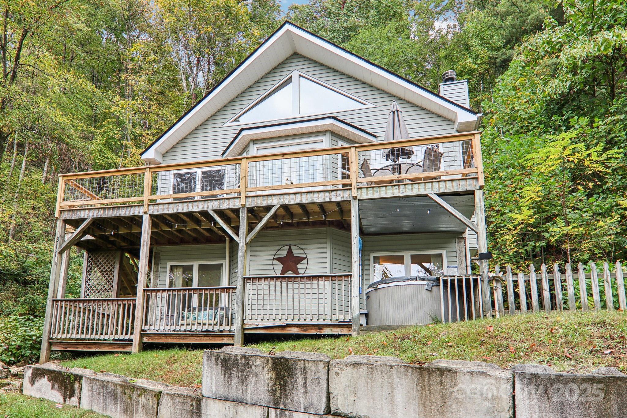 a view of a house with a small yard and wooden fence
