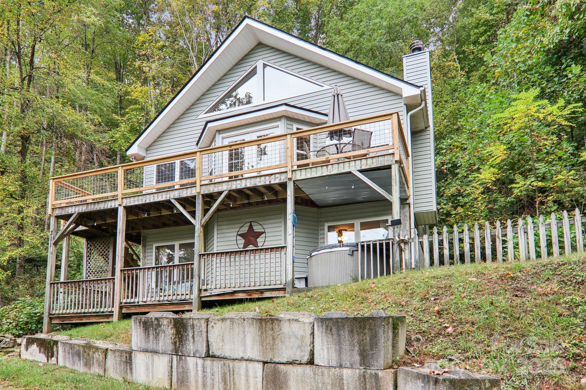 311 Jacks Knob Road Barnardsville, NC 28709 - Photo 2 of 48 a view of house with large windows and wooden fence
